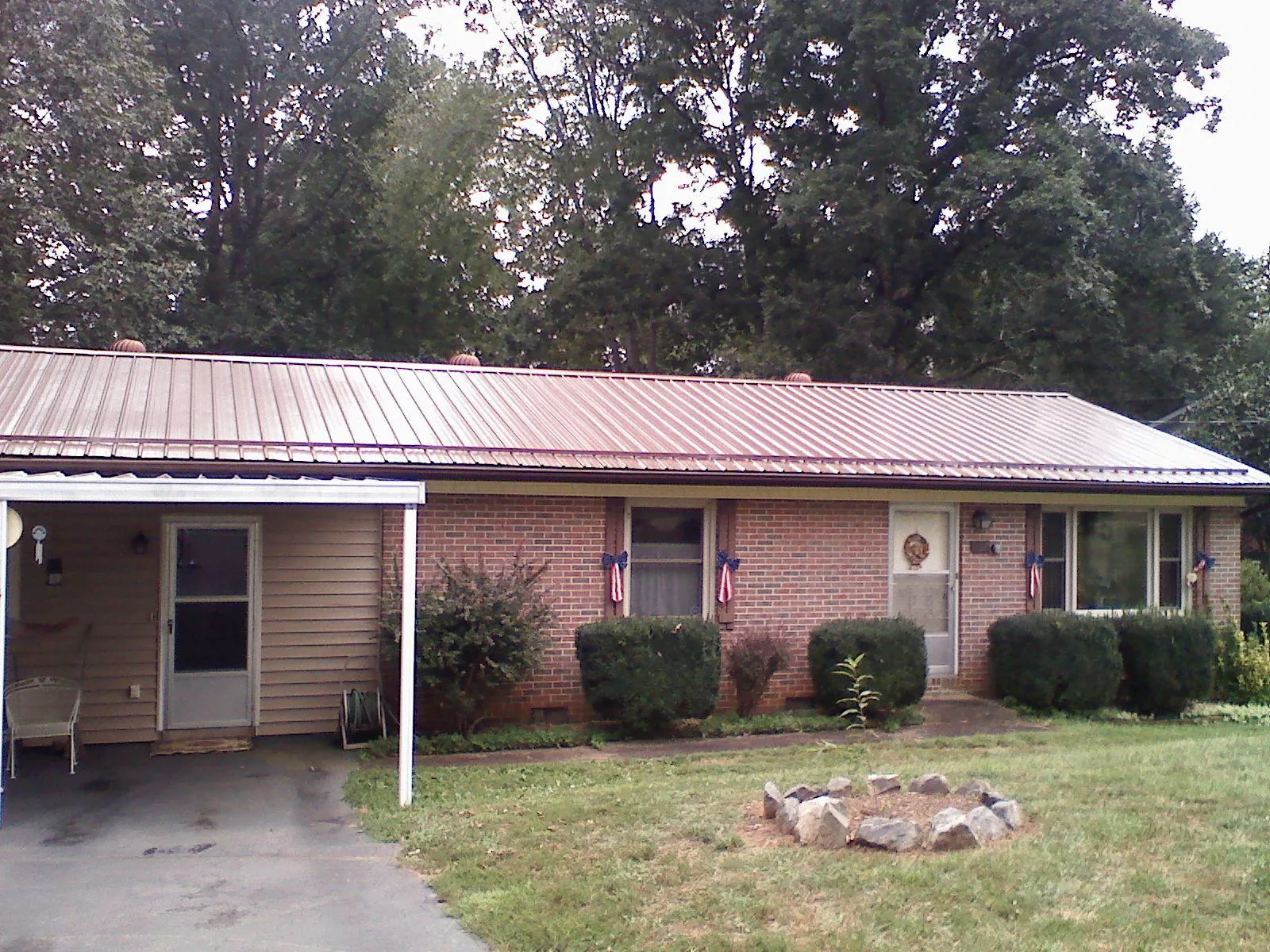 Bronze metal roof and carport on a brick ranch home — Roof Repair work by our crew in Montgomery